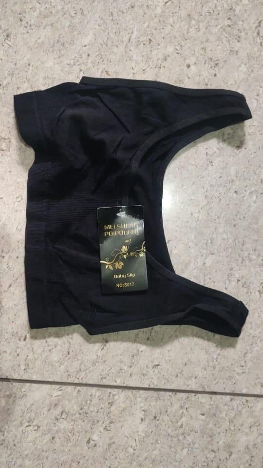Black garment with a label on a textured surface