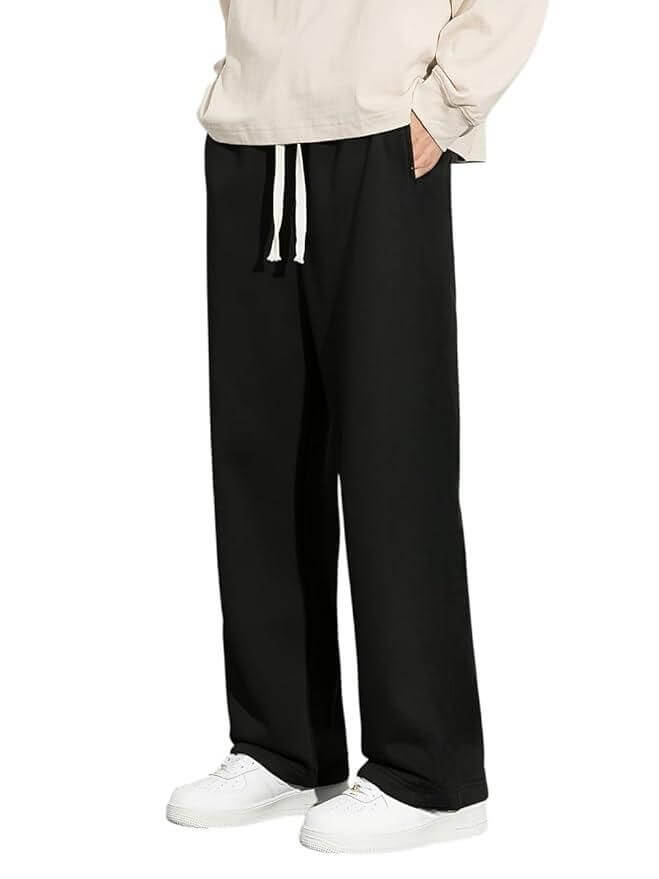 Person wearing black wide-leg pants with a white background
