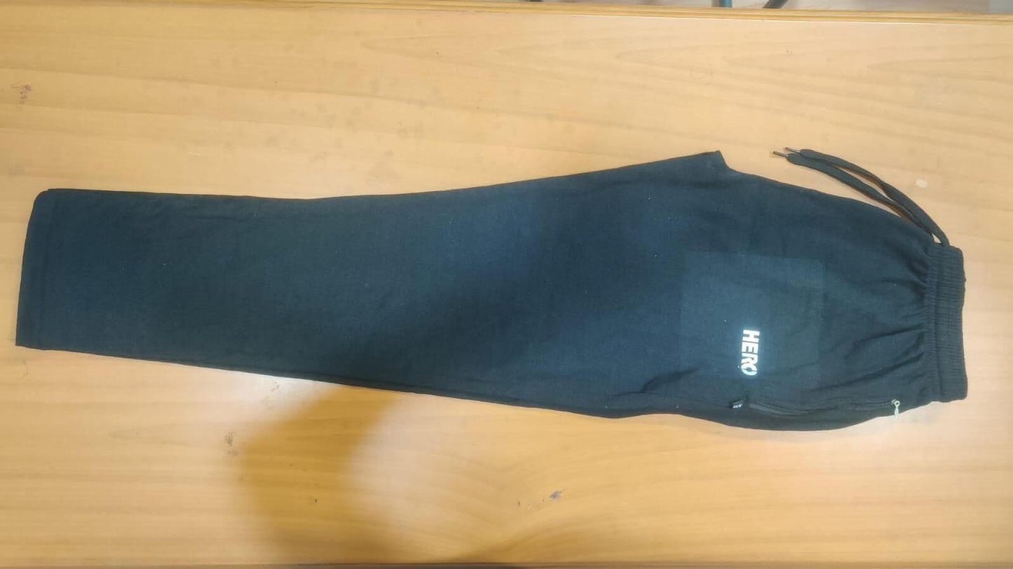 Black pants with 'Hero' branding on a wooden surface