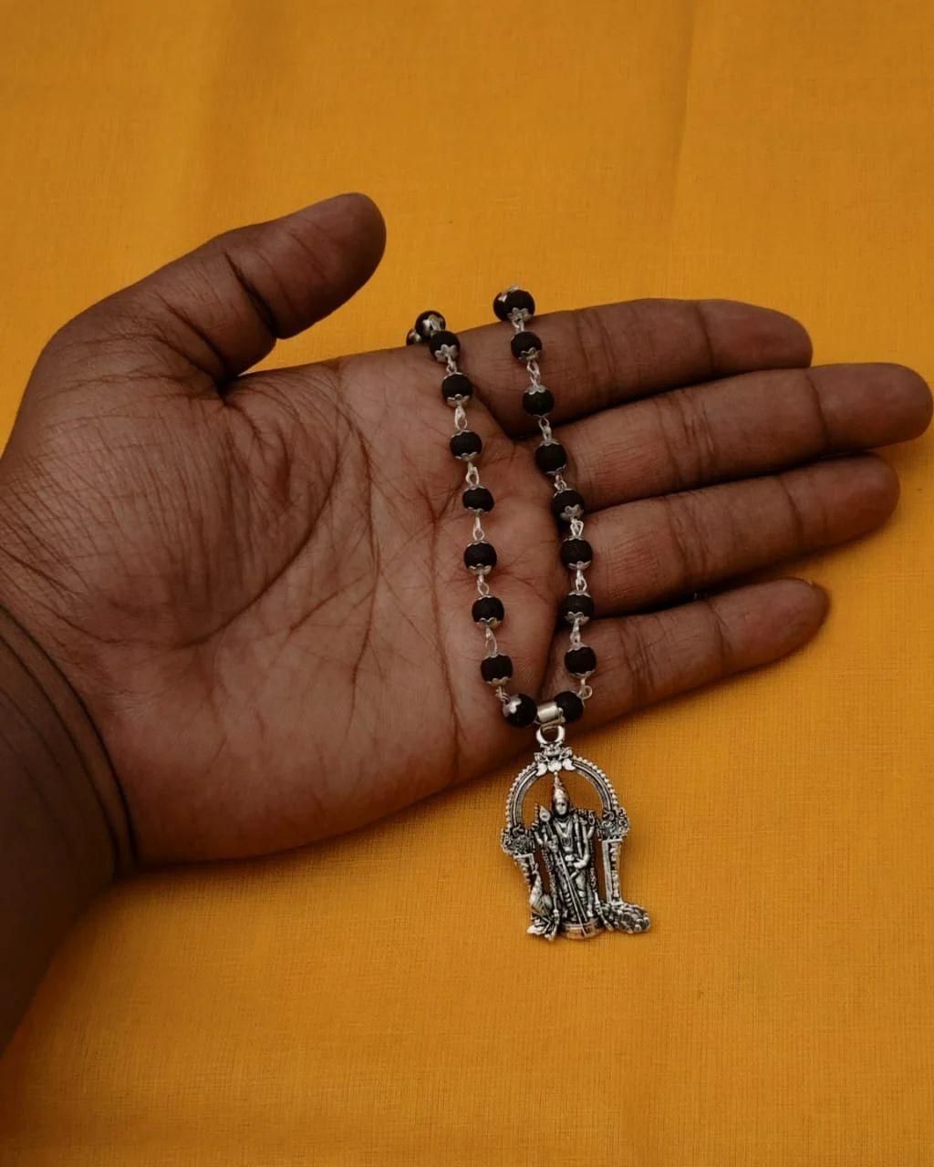 Karungali Mala with Murugan Locket displayed in hand, showcasing traditional black beads and spiritual design.