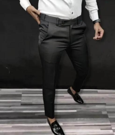 Person wearing black pants and white shirt against a dark background