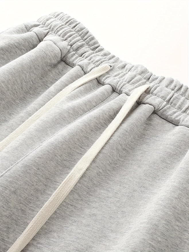 Close-up of gray sweatpants with drawstring on a white background