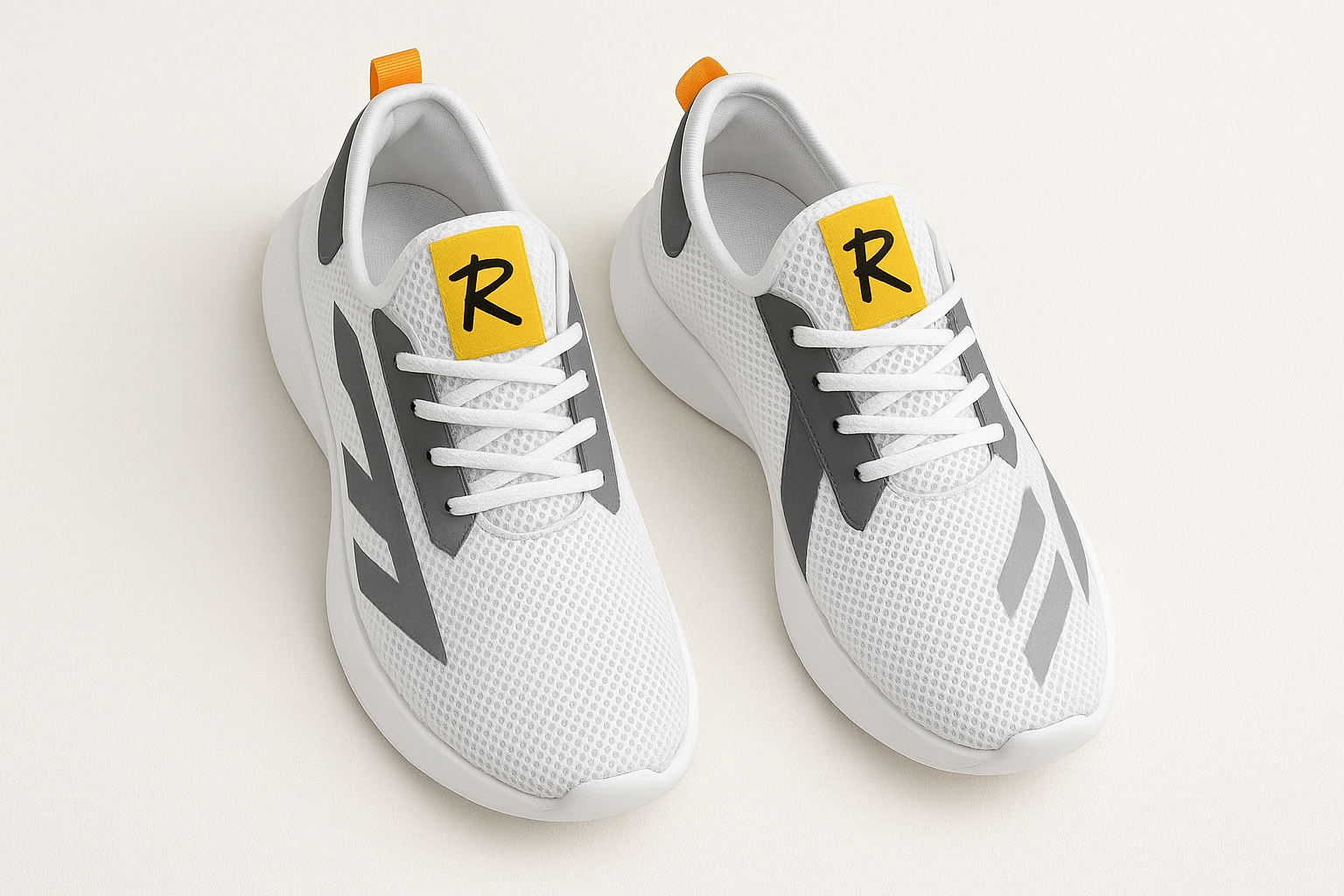 White athletic shoes with gray accents and a yellow logo on a light background