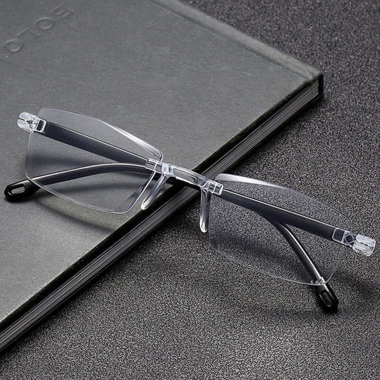 Clear rimless eyeglasses on a black surface with a notebook
