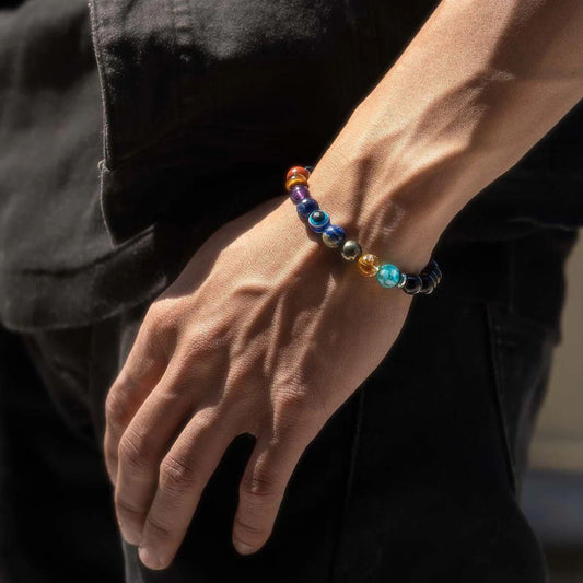 Close-up of a hand wearing a Super 9 Chakra Healing Bracelet against a dark background